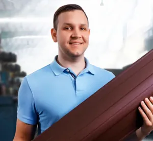 Сергей Даровской, руководитель отдела продаж, с листом профнастила